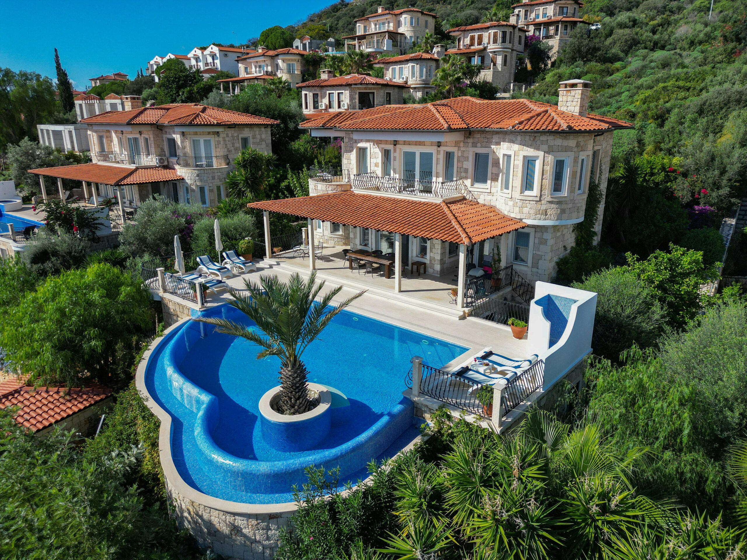 Elegant villa with stunning infinity pool surrounded by lush greenery and scenic views.